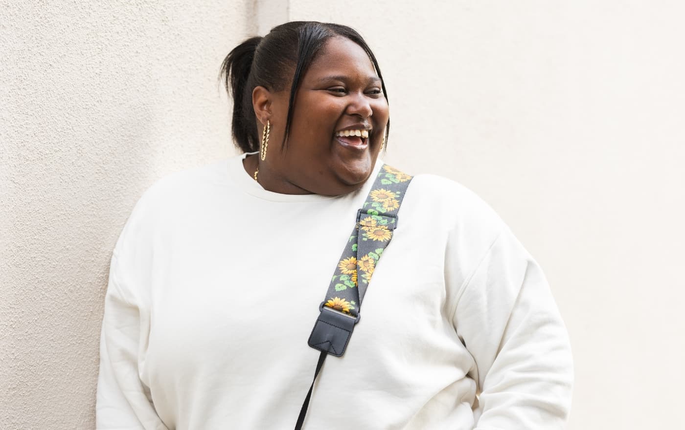 Young woman smiling confidently outdoors — the clarity and wellbeing that psychiatric care at MMHC can help you find