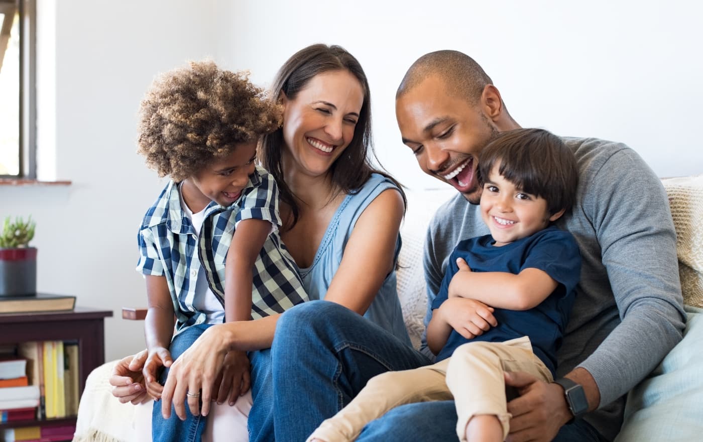 Happy family laughing together at home — the connection and joy that therapy at Minnesota Mental Health Clinics helps restore