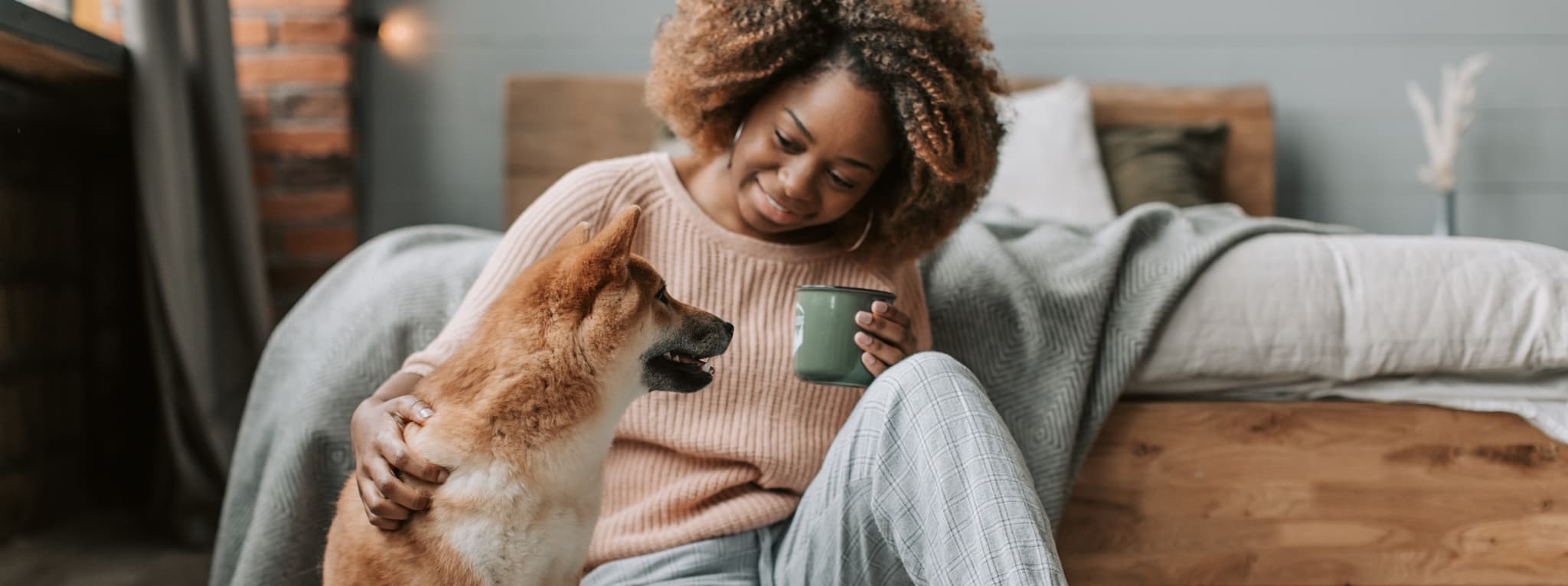 Woman smiling peacefully at home with her dog — the grounding and healing that trauma care at Minnesota Mental Health Clinics supports
