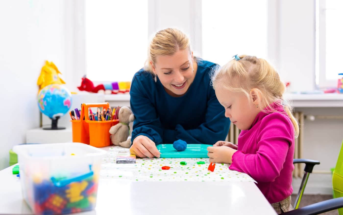 Therapist and young child working together with clay during a play therapy session at Minnesota Mental Health Clinics