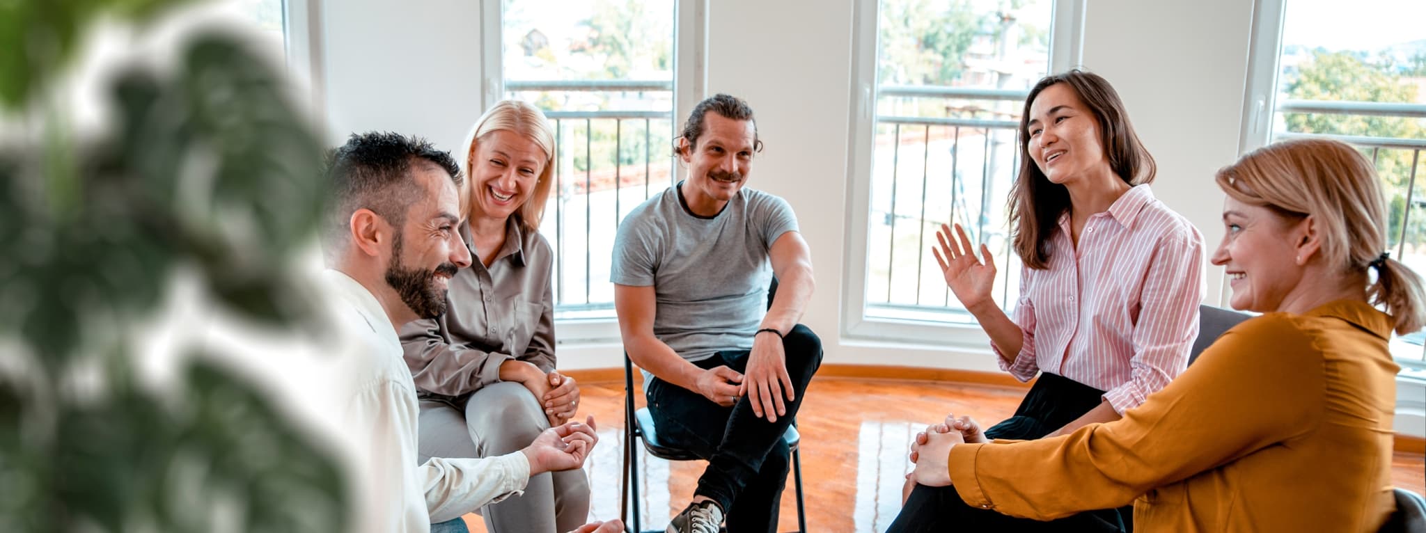 Adults sitting in a circle during a group therapy session β the community and support that group therapy builds at MMHC