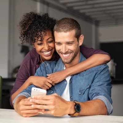 Young diverse couple looking at phone together for a telehealth couples therapy session