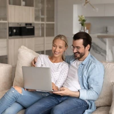 Couple relaxing on the couch together during a telehealth couples therapy session